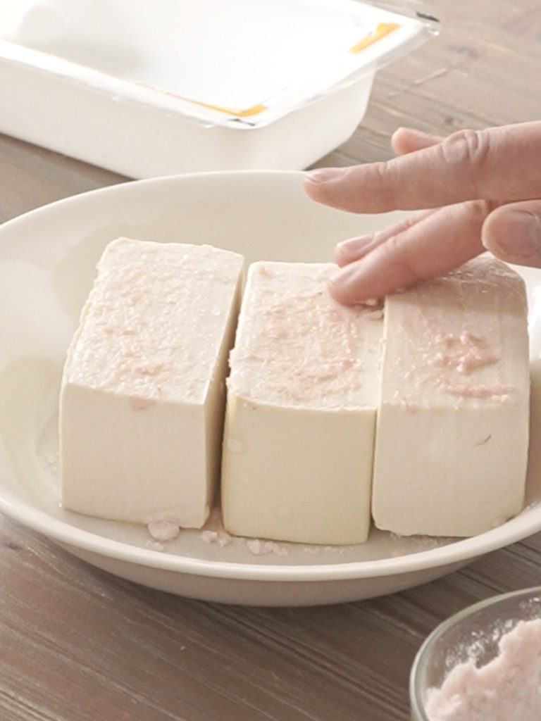 demonstrated one of the steps of salting tofu